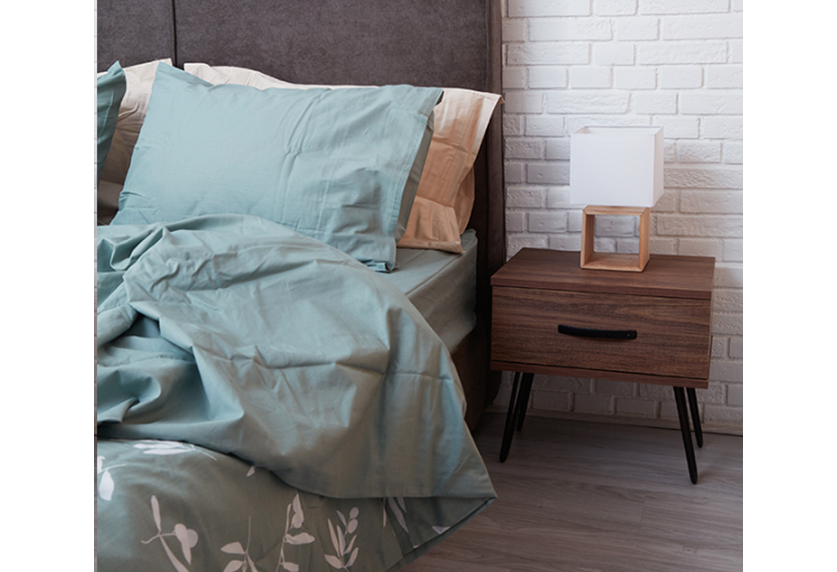 Το κομοδίνο τοποθετημένο δίπλα σε ένα κρεβάτι.